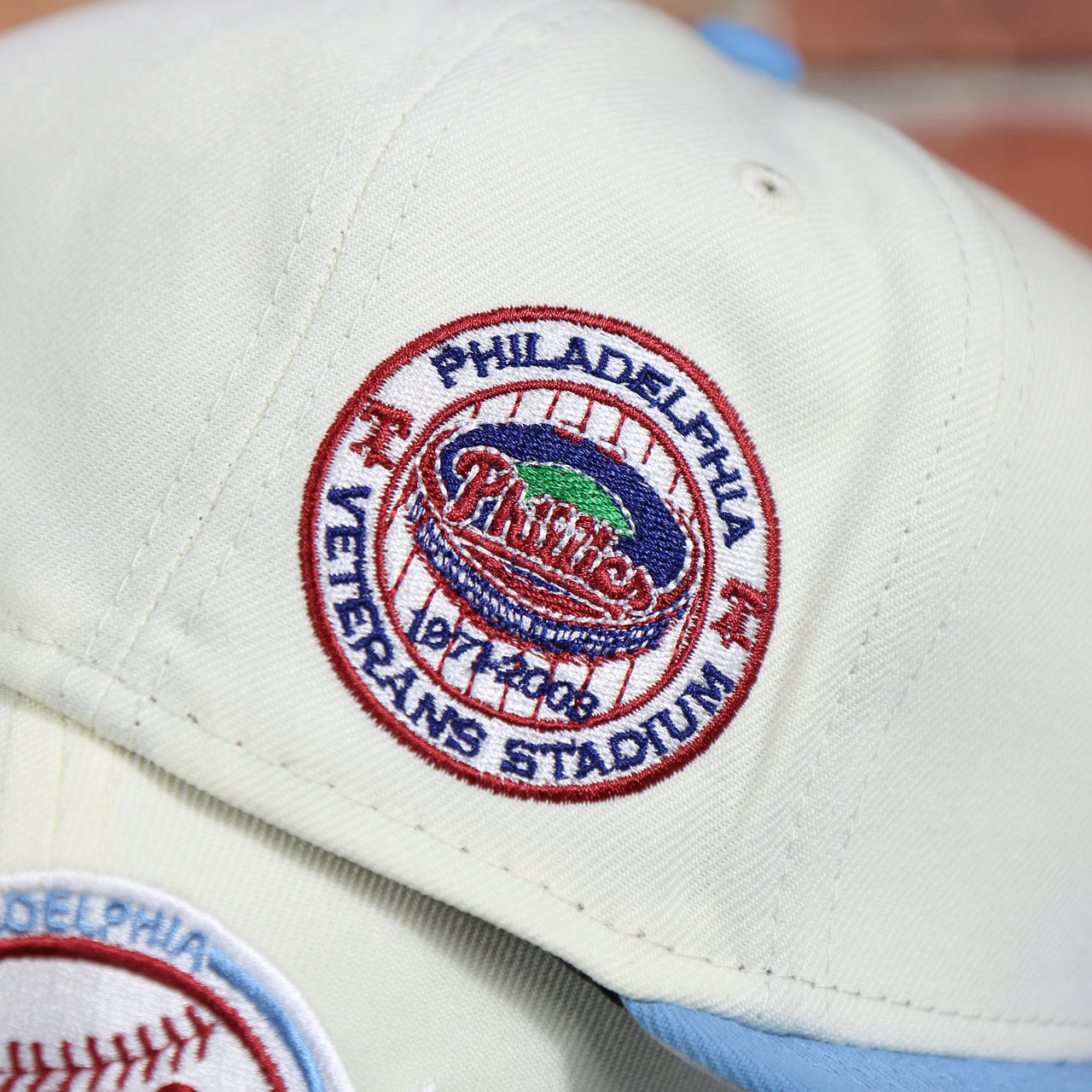 Close up of the Veterans Stadium side patch on the Philadelphia Phillies Cooperstown City Hall Logo Veterans Stadium Side Patch Grey UV 59Fifty Fitted Cap | Chrome/Powder Blue Cap Swag Exclusive