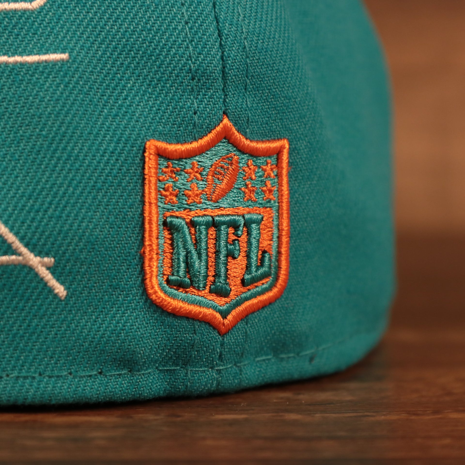 Close up of the NFL shield on the back of the Miami Dolphins City Transit All Over Side Patch Gray Bottom 59Fifty Fitted Cap