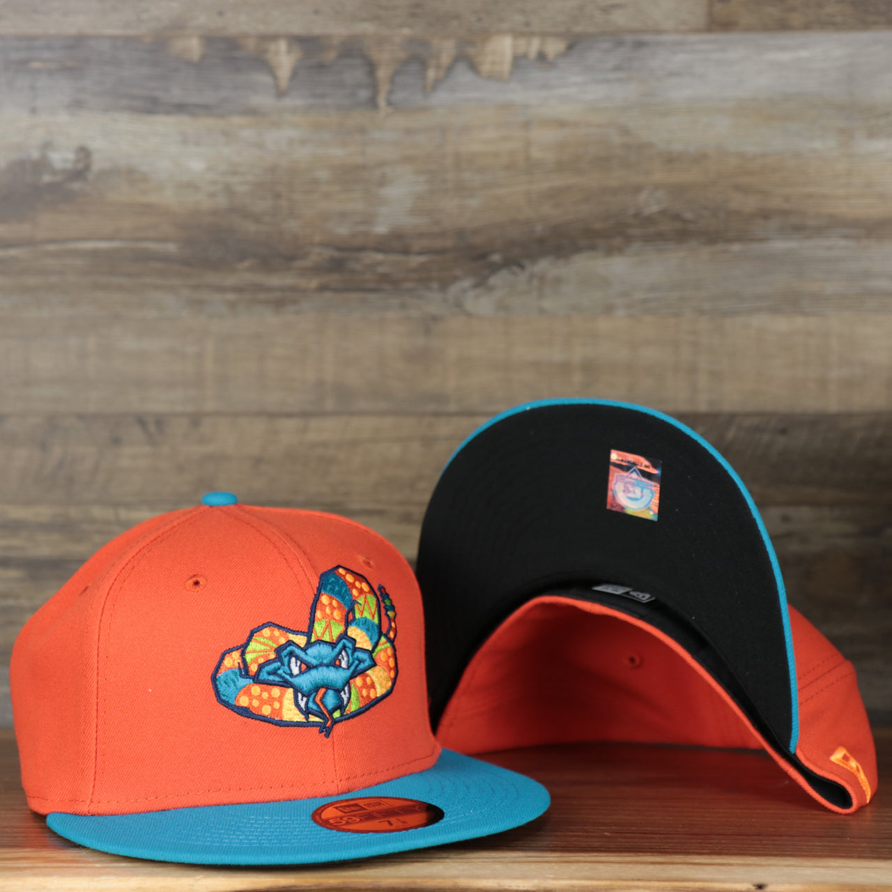front and bottom of the Wisconsin Timber Rattlers 2022 Cascabeles de Wisconsin Copa On-Field Black Bottom 5950 Fitted Cap | Orange