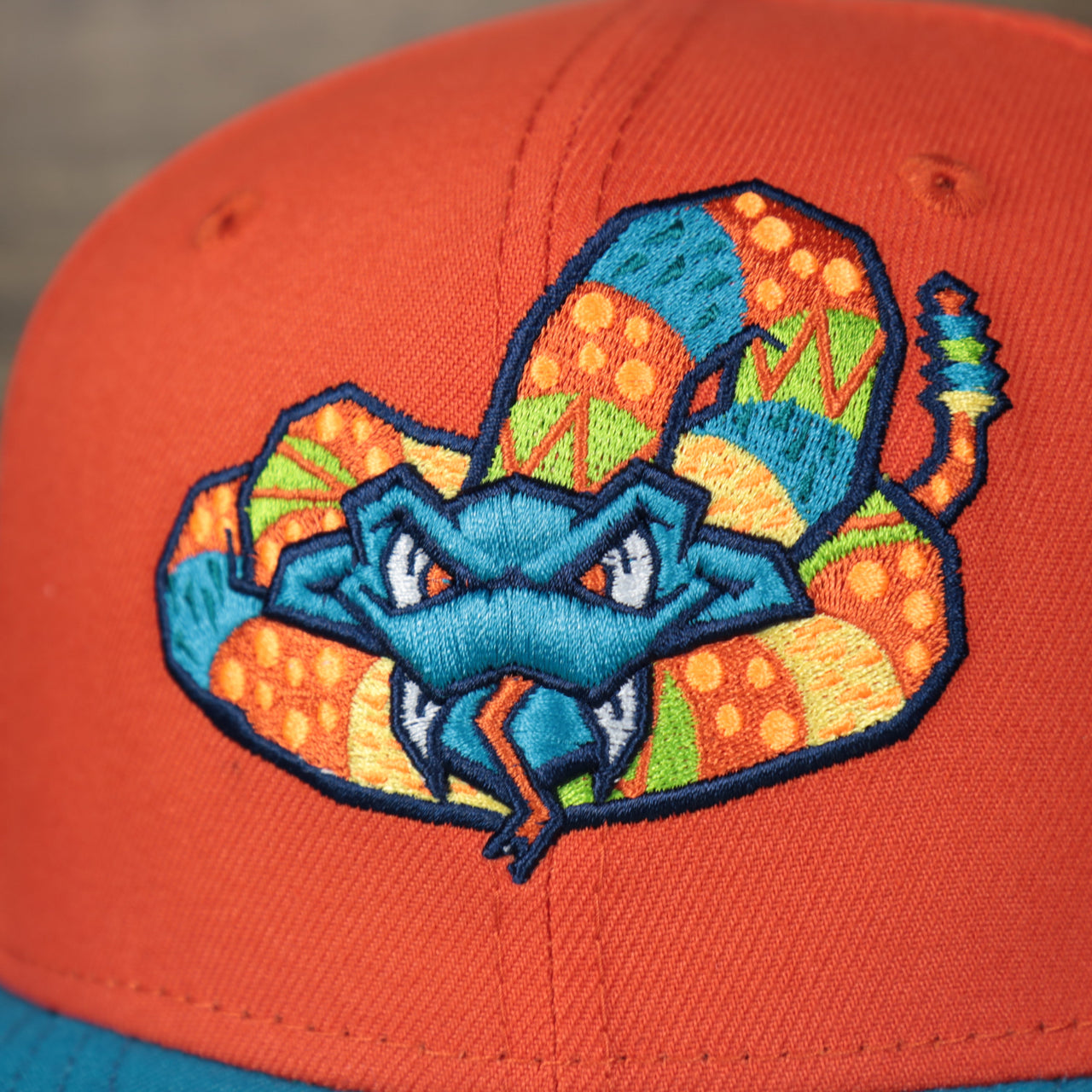 front logo on the Wisconsin Timber Rattlers 2022 Cascabeles de Wisconsin Copa On-Field Black Bottom 5950 Fitted Cap | Orange