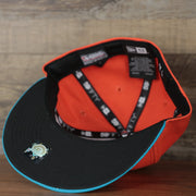 underside of the Wisconsin Timber Rattlers 2022 Cascabeles de Wisconsin Copa On-Field Black Bottom 5950 Fitted Cap | Orange