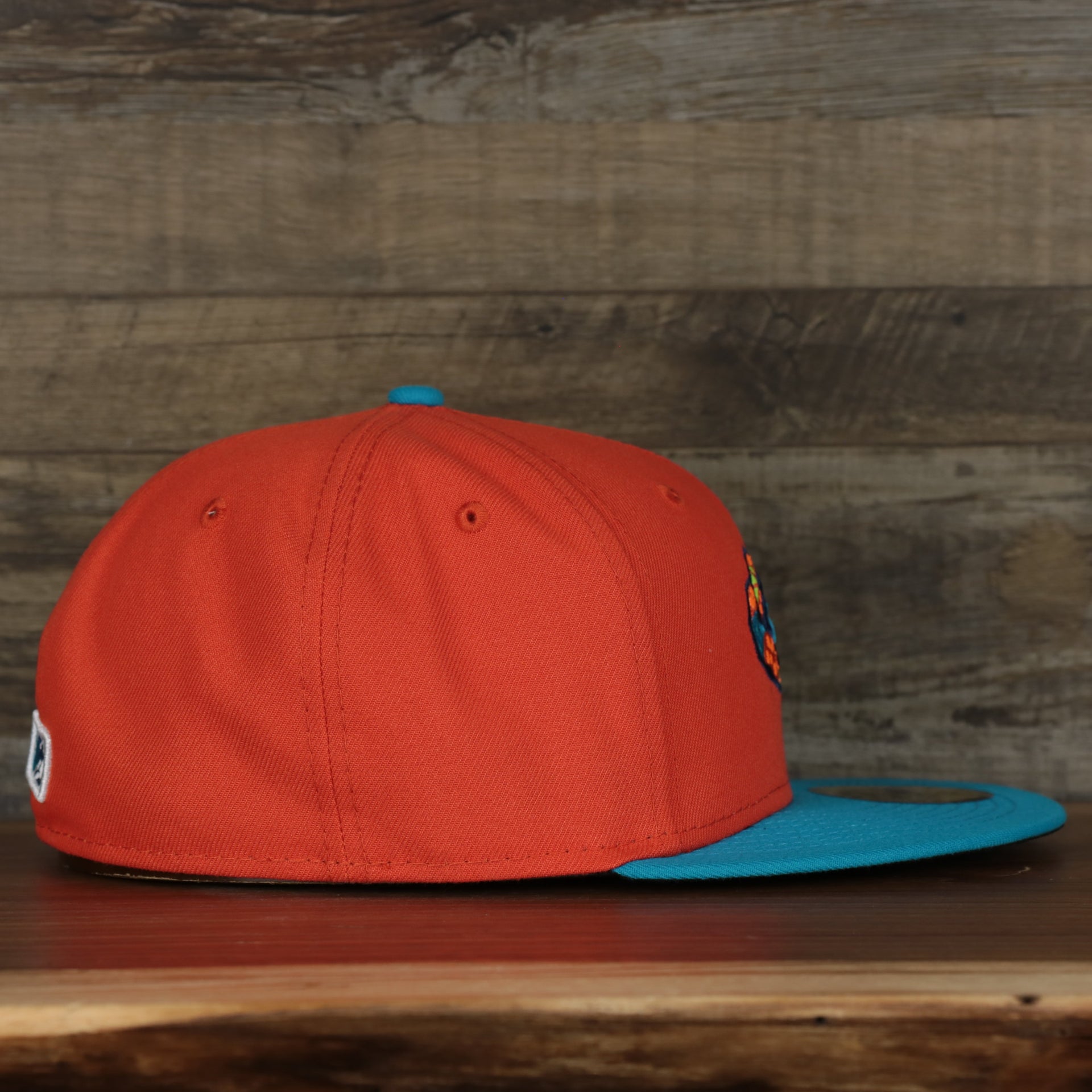 wearers right side of the Wisconsin Timber Rattlers 2022 Cascabeles de Wisconsin Copa On-Field Black Bottom 5950 Fitted Cap | Orange