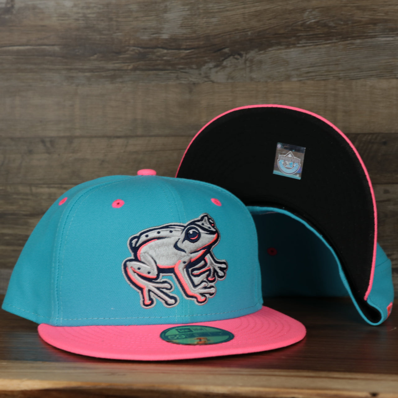 front and bottom of the Leigh Valley Iron Pigs 2022 Coquis de Leigh Valley Copa de la Diversion On-Field Black Bottom 5950 Fitted Cap | Blue/Pink