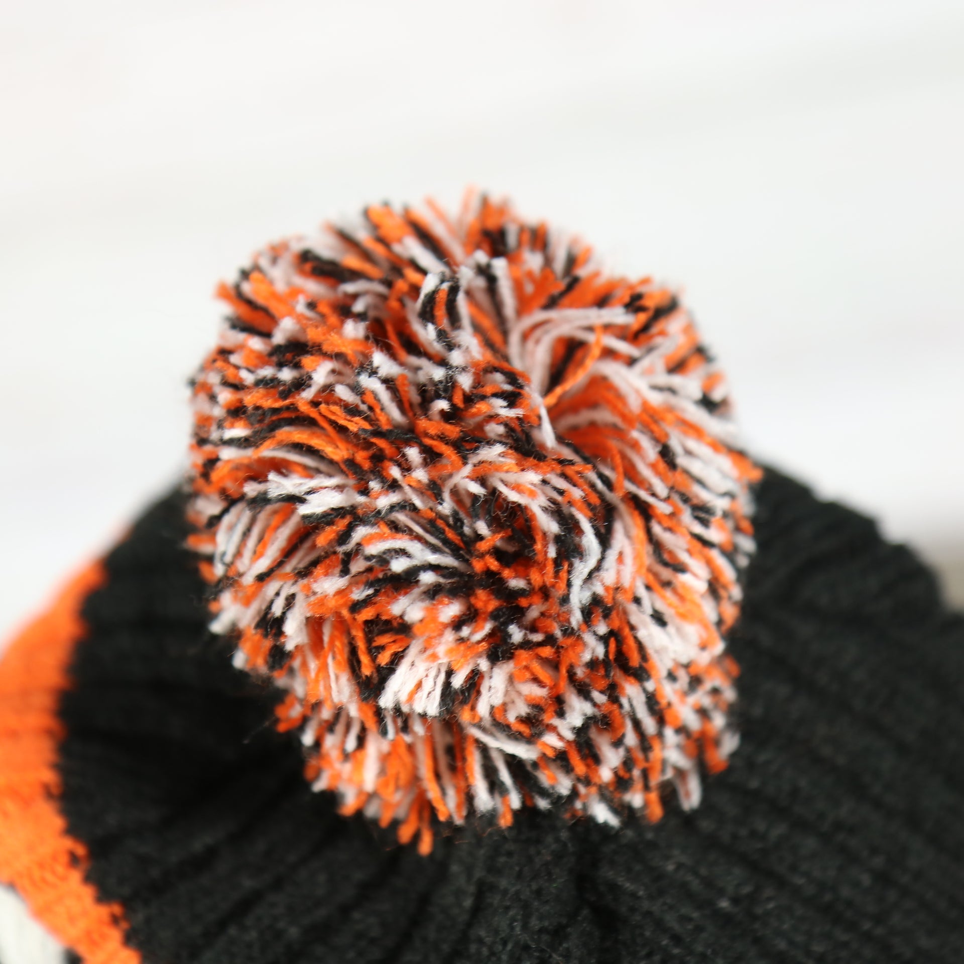 pom pom on the Philadelphia Flyers Two Sided Cuffed Winter Beanie | Orange, White, And Black Winter Beanie