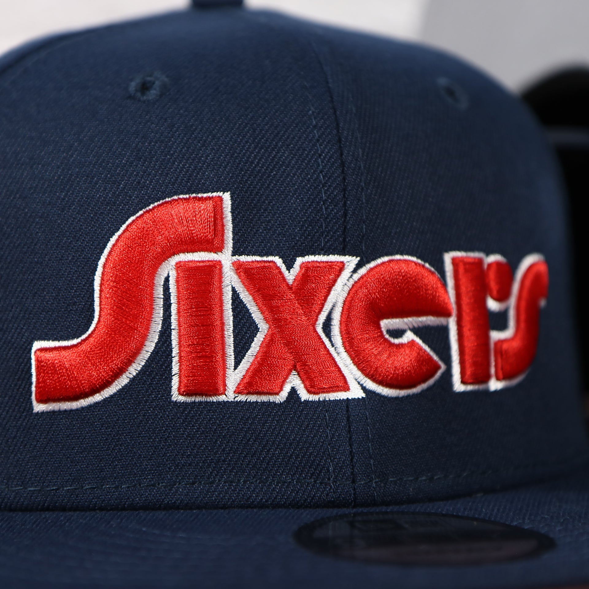 Close up of the Sixers wordmark script on the Philadelphia 76ers 2022 City Edition Sixers Script Spectrum Side Patch 9Fifty Snapback Hat