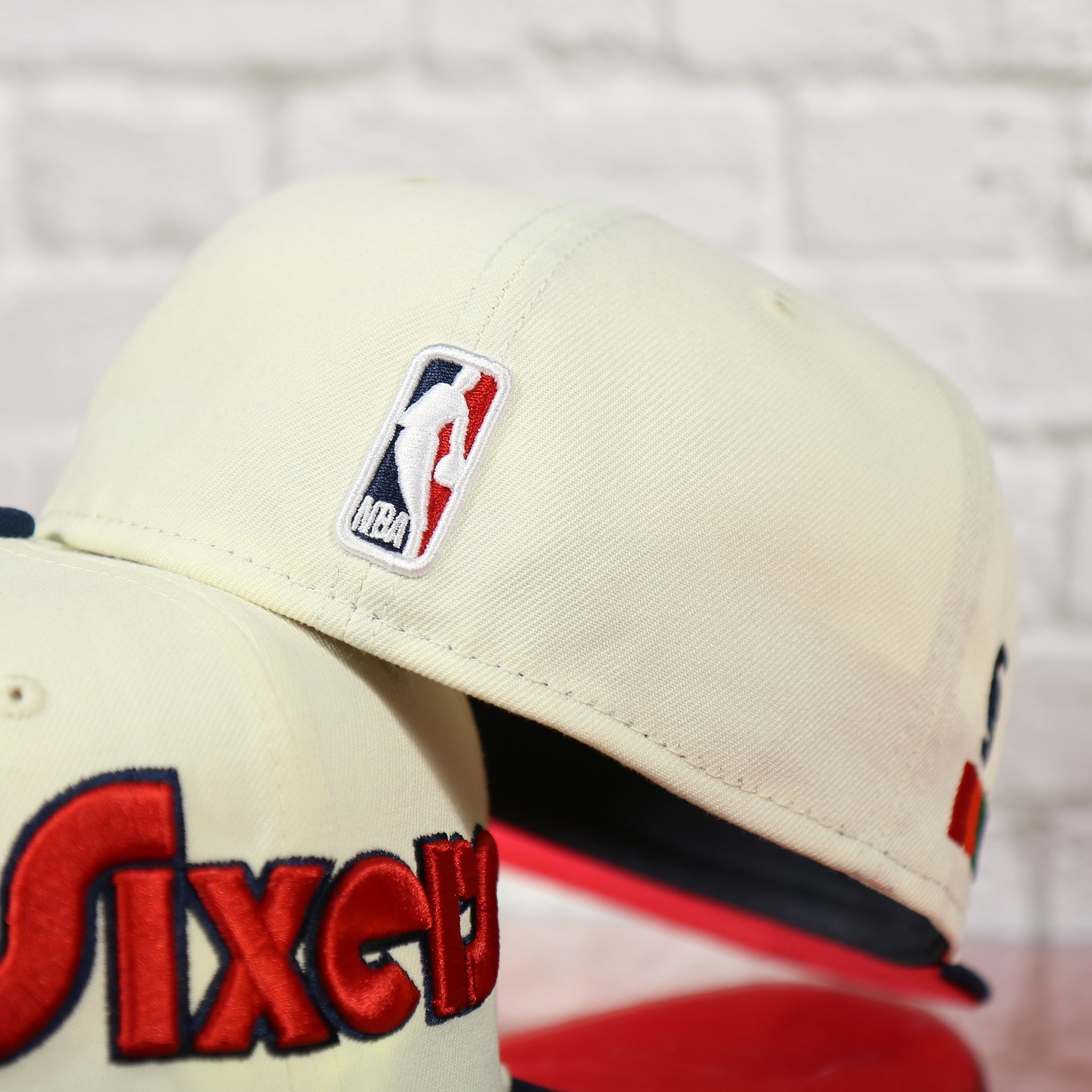 NBA logo on the back of the Philadelphia 76ers 2022 City Edition Sixers Script Spectrum Side Patch Chrome/Navy 59Fifty Fitted Cap