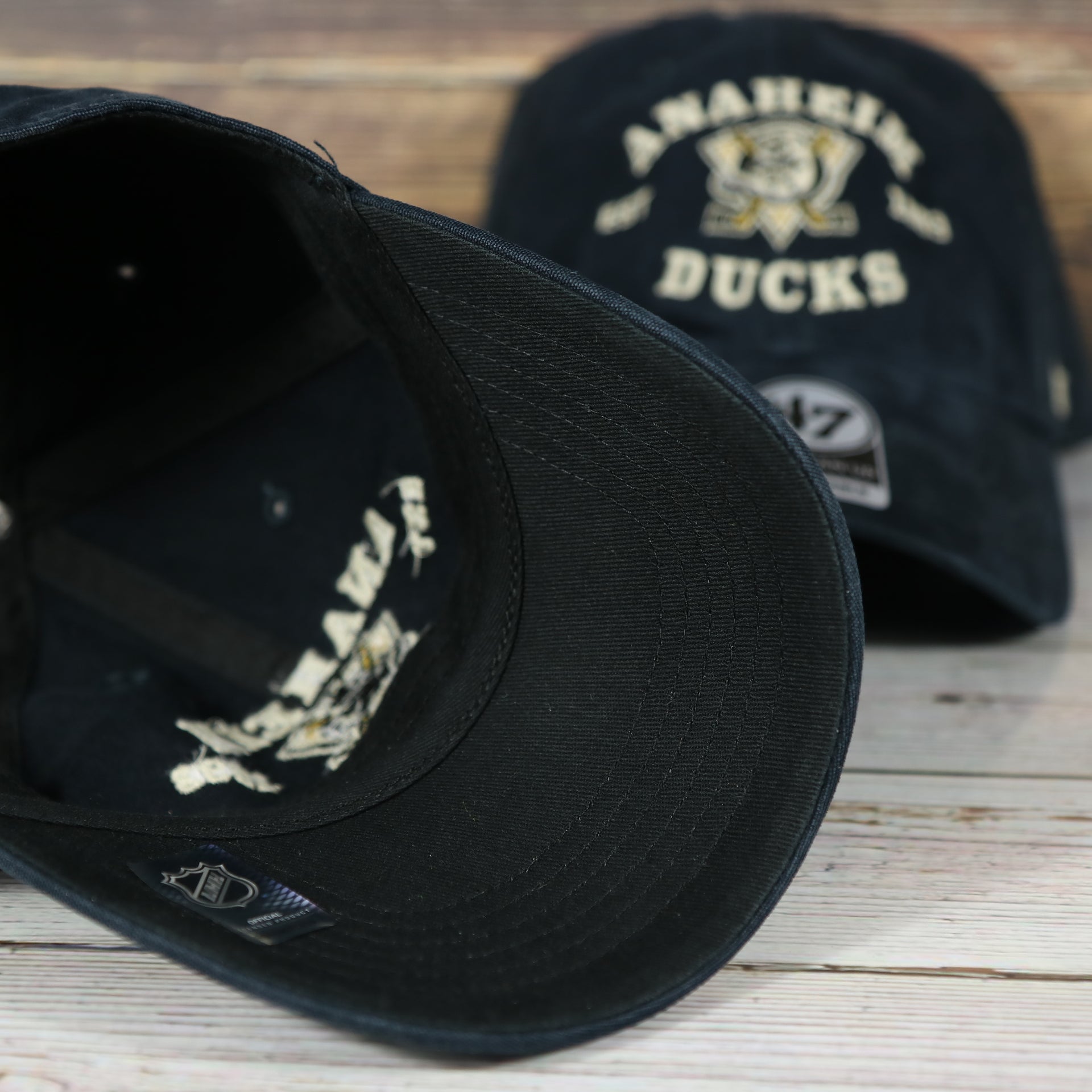 bottom of the Anaheim Ducks Throwback Distressed Black Dad Hat | Black Adjustable Baseball Cap