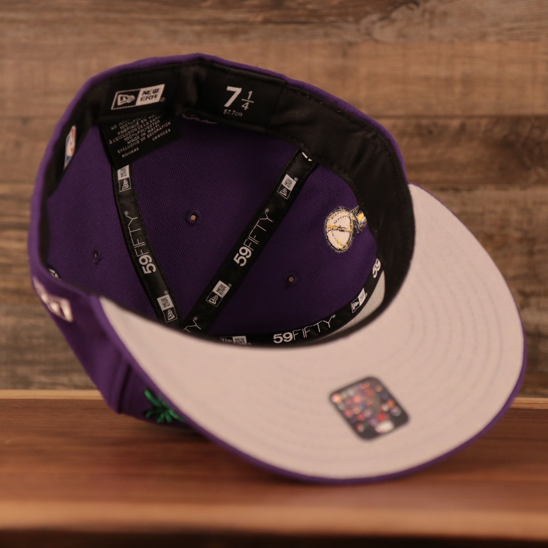 An inside view of the crown of the grey brim fitted Los Angeles Lakers purple all over embroidered patch fitted 5950 cap by New Era.