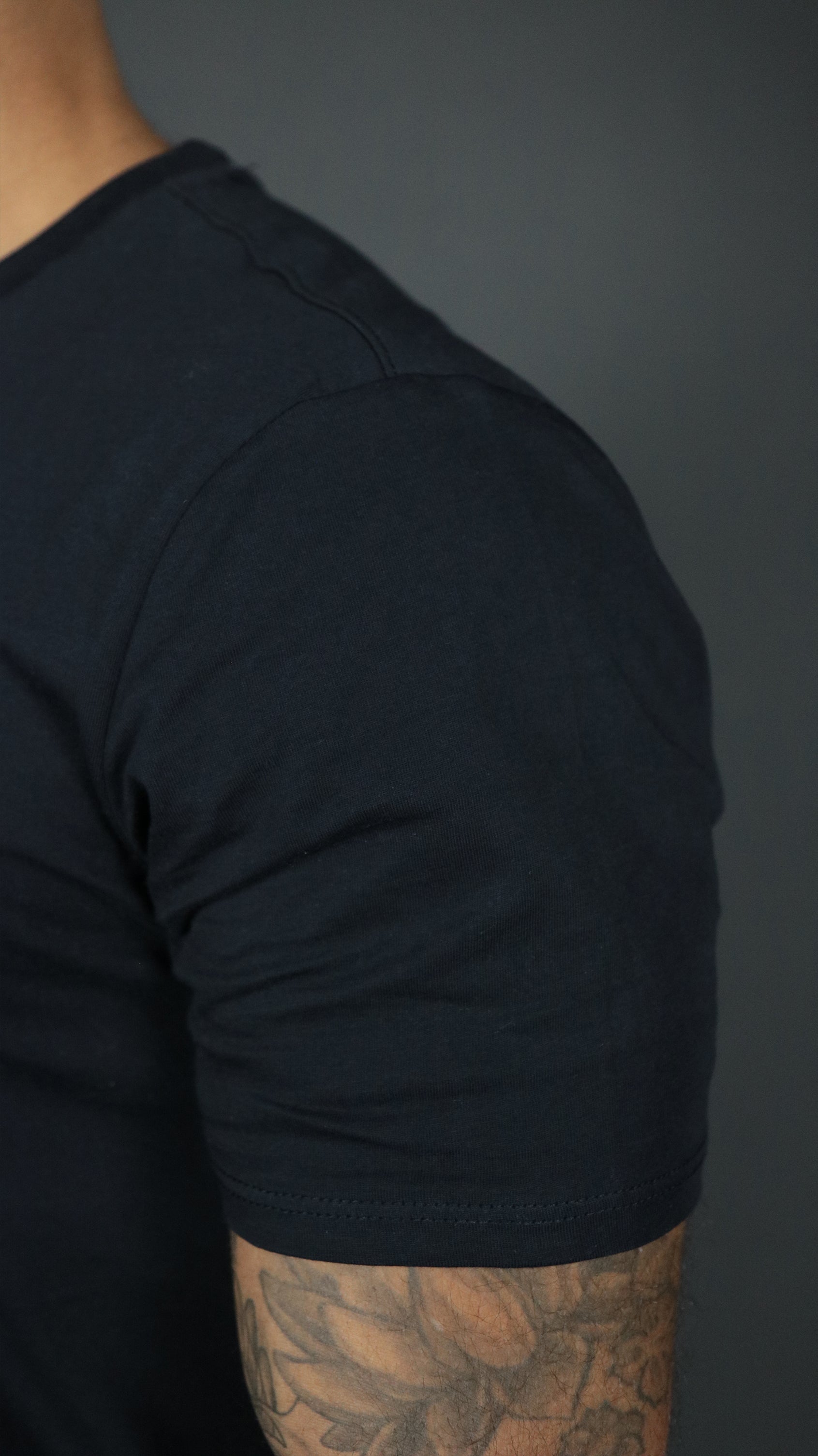 Left shoulder of the navy Jordan Craig longline scoop bottom t shirt.