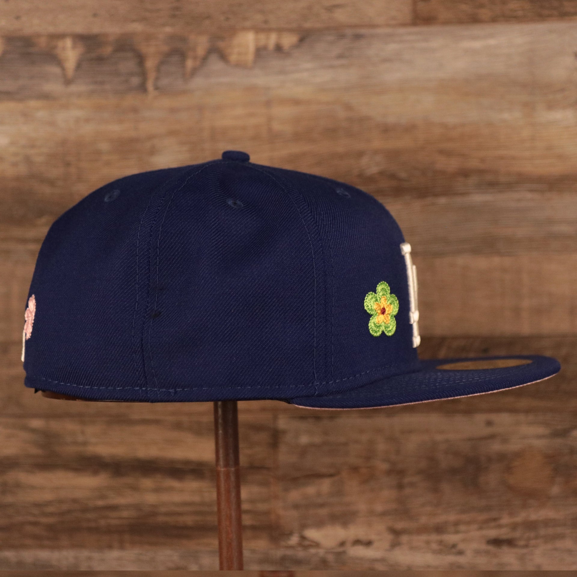 Wearer's right of the Los Angeles Dodgers All Over Floral Pattern Flower Crotchet Side Patch Pink Bottom 59Fifty Fitted Cap