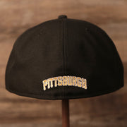 The backside of the New Era black fitted cap has Pittsburgh written in old english format.