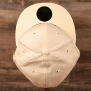 A top view of the crown of the cream Philadelphia Eagles green bottom retro kelly logo fitted 59fifty hat by New Era.