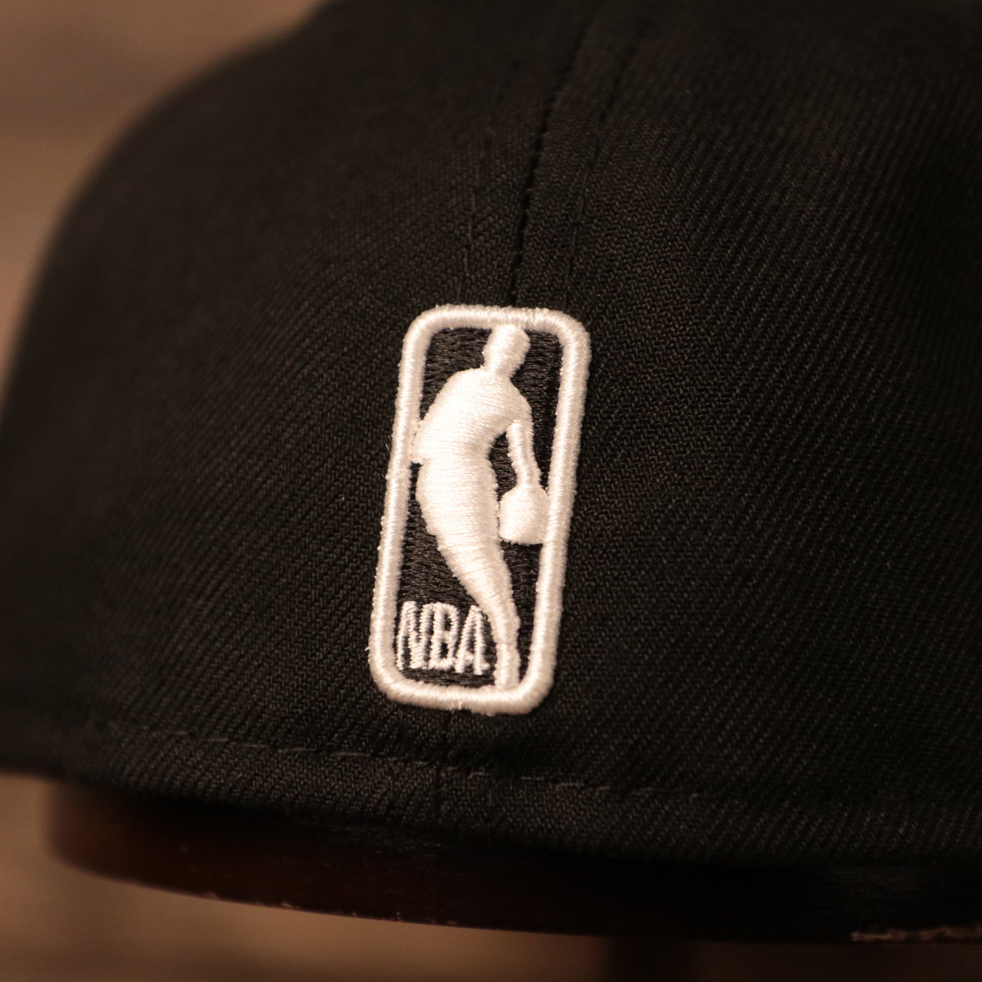 The back side of the black 17x Los Angeles Lakers champs hat has the white logo of NBA.