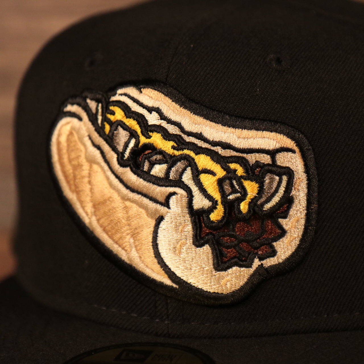 The Philly cheesesteak with onions patch on the front of the black Lehigh Valley Iron Pigs New Era fitted cap.
