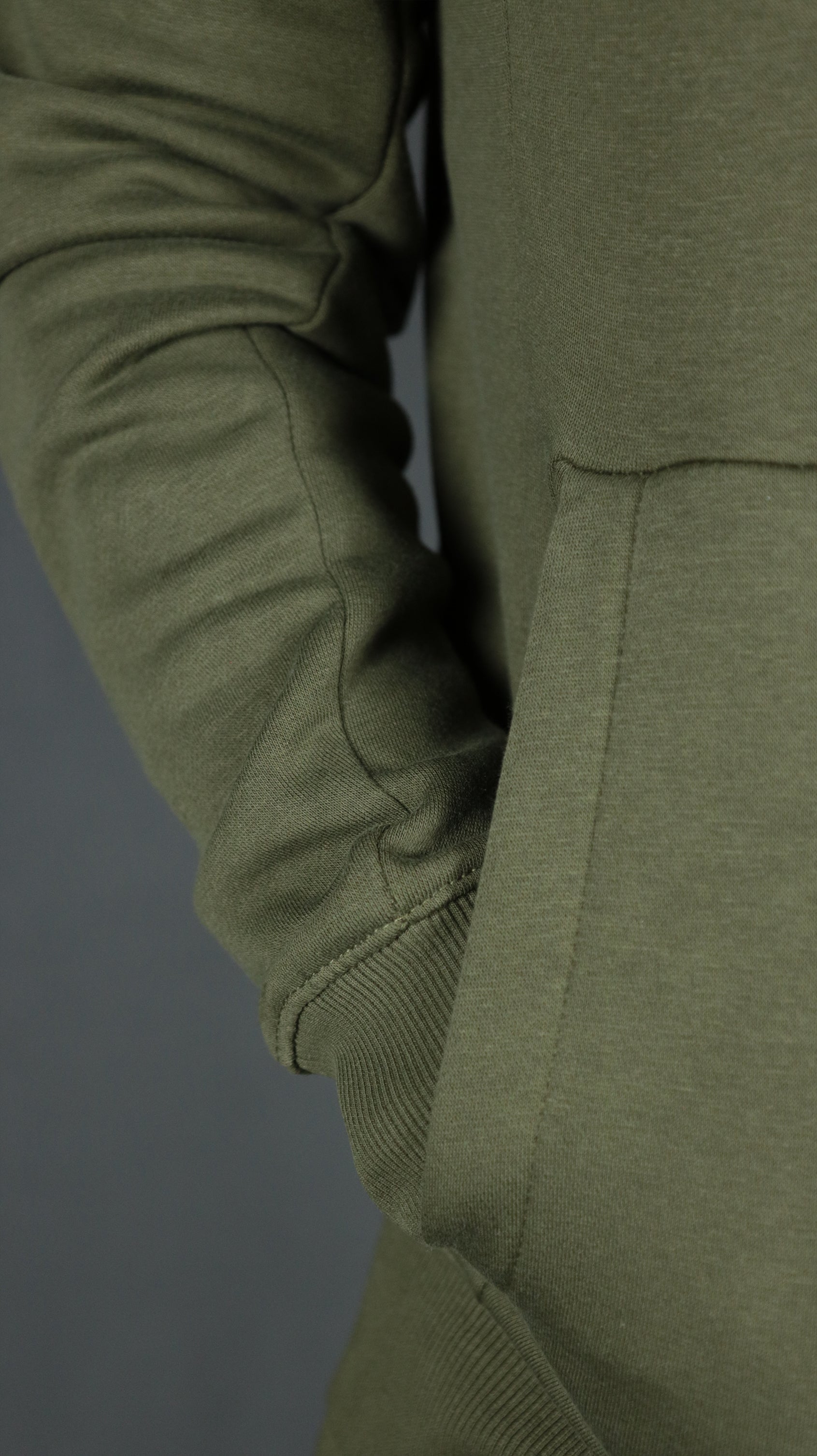 One of the two pockets of the military olive green basic tech fleece hoodie by Jordan Craig.
