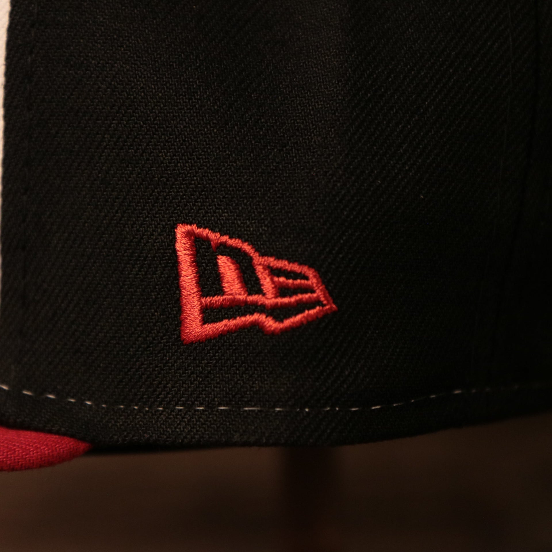 The logo of New Era on the right side of the black luchadores de reading fitted cap.