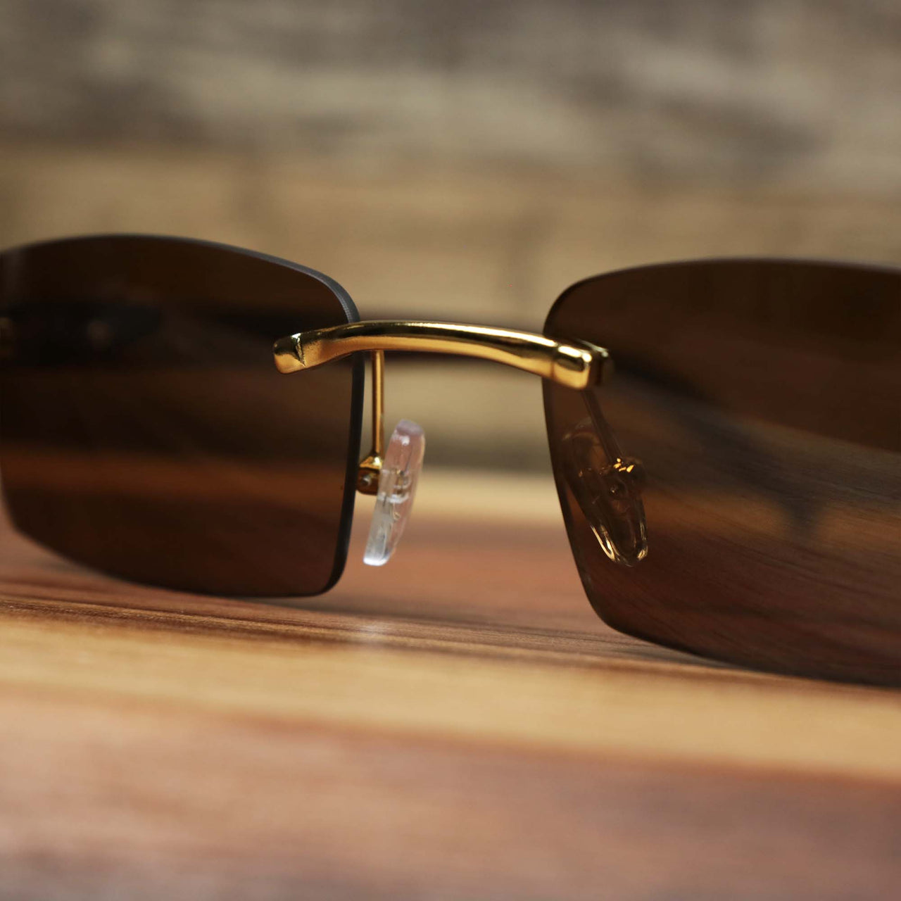 The bridge of the Rectangle Wood and Metal Frame Brown Lens Sunglasses with Gold Frame