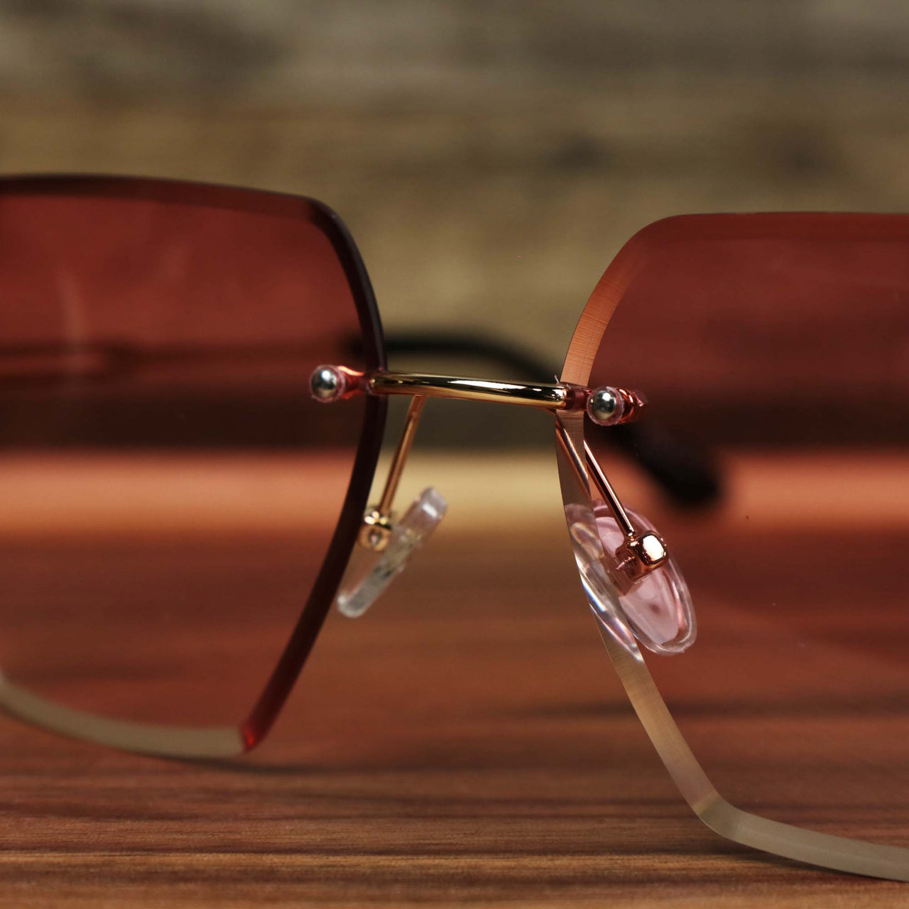 A close up of the bridge on the Large Lightweight Frame Pink Lens Sunglasses with Rose Gold Frame