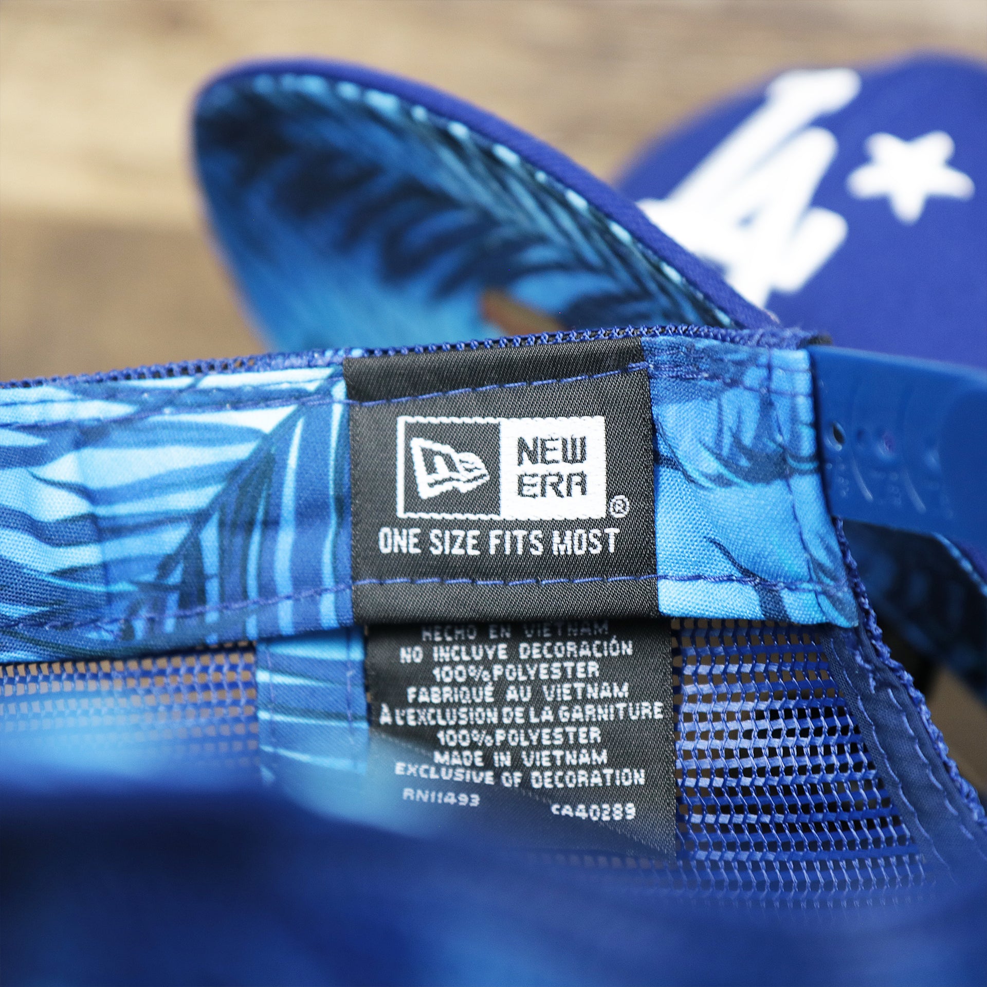 The New Era Tag on the Los Angeles Dodgers Metallic All Star Game MLB 2022 Side Patch 9Fifty Mesh Snapback | ASG 2022 Royal Blue Trucker Hat