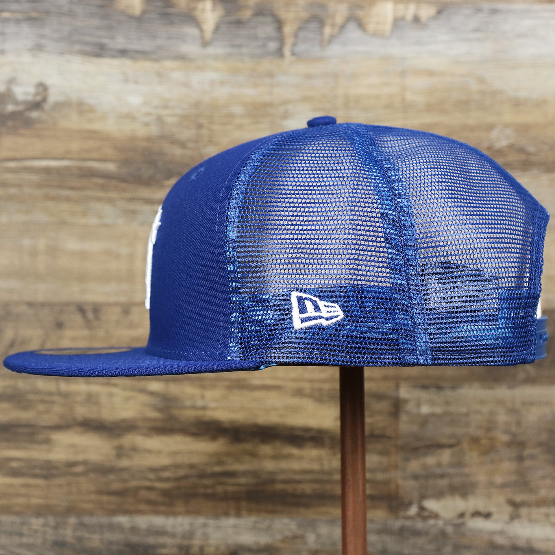 The wearer's left on the Los Angeles Dodgers Metallic All Star Game MLB 2022 Side Patch 9Fifty Mesh Snapback | ASG 2022 Royal Blue Trucker Hat