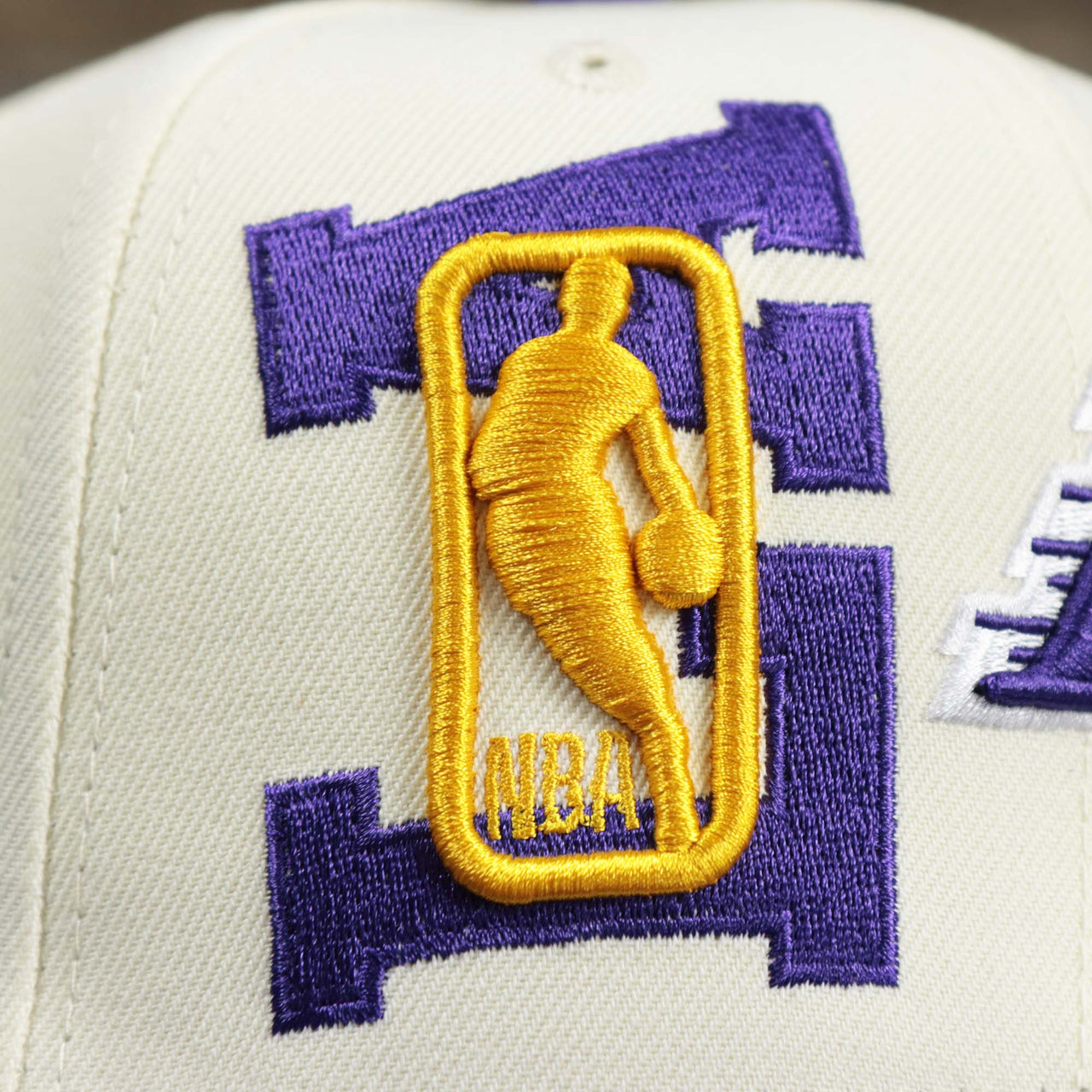 The NBA Jerry West Logo overtop LA on the Youth Los Angeles Lakers NBA 2022 Draft Gray Bottom 9Fifty Snapback | New Era Cream/Purple