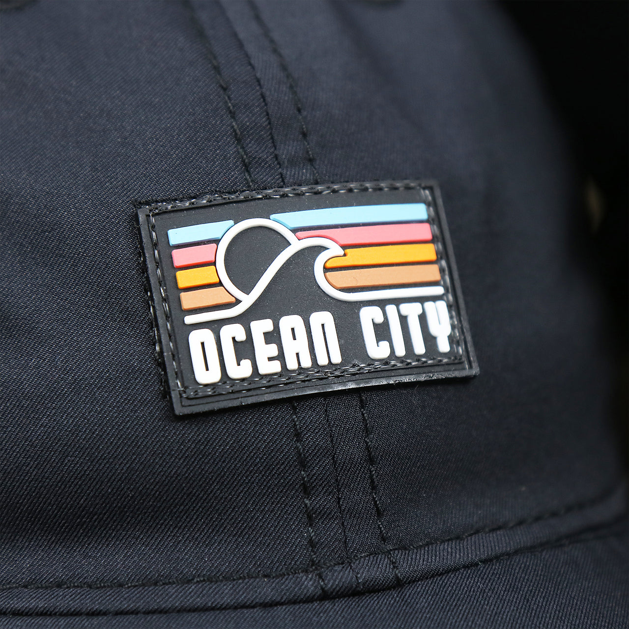 The Ocean City Sunset Rubber Patch on the New Jersey High Point PVC Ocean City Rubber Patch Cool Fit Adjustable Dad Hat | Black Dad Hat