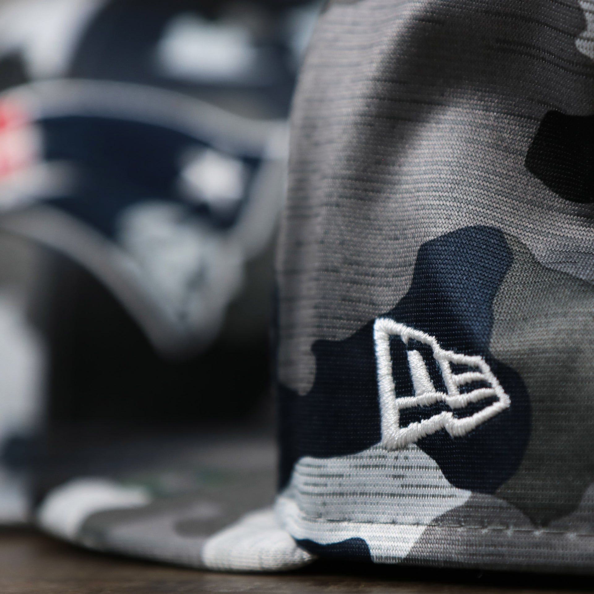 The New Era Logo on the New England Patriots NFL OnField Summer Training 2022 Camo 9Fifty Snapback | Navy Blue Camo 9Fifty