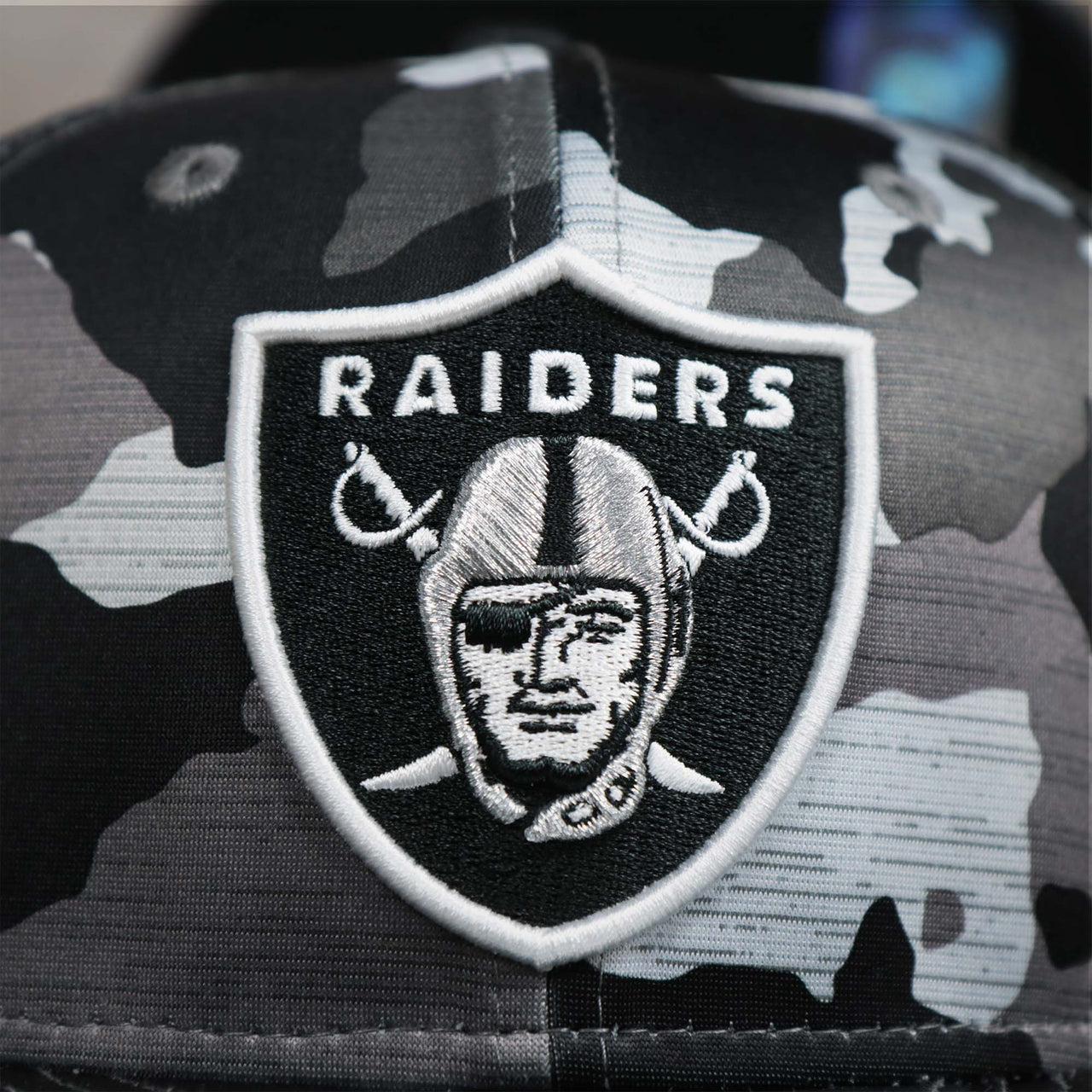 The Raiders Logo on the Los Angeles Raiders NFL OnField Summer Training 2022 Camo 9Fifty Snapback | Black Camo 9Fifty