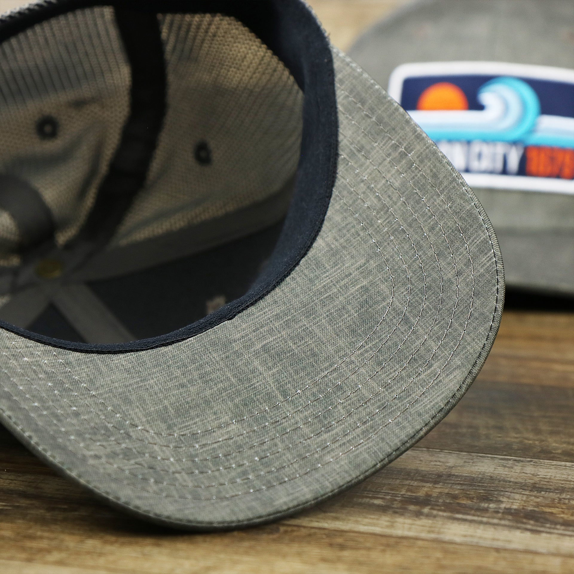 The undervisor on the OCNJ Ocean City 1879 Sunset Wave Logo Mesh Stretch FIt Hat | Dark Green And Dark Grey Stretch Fit Hat