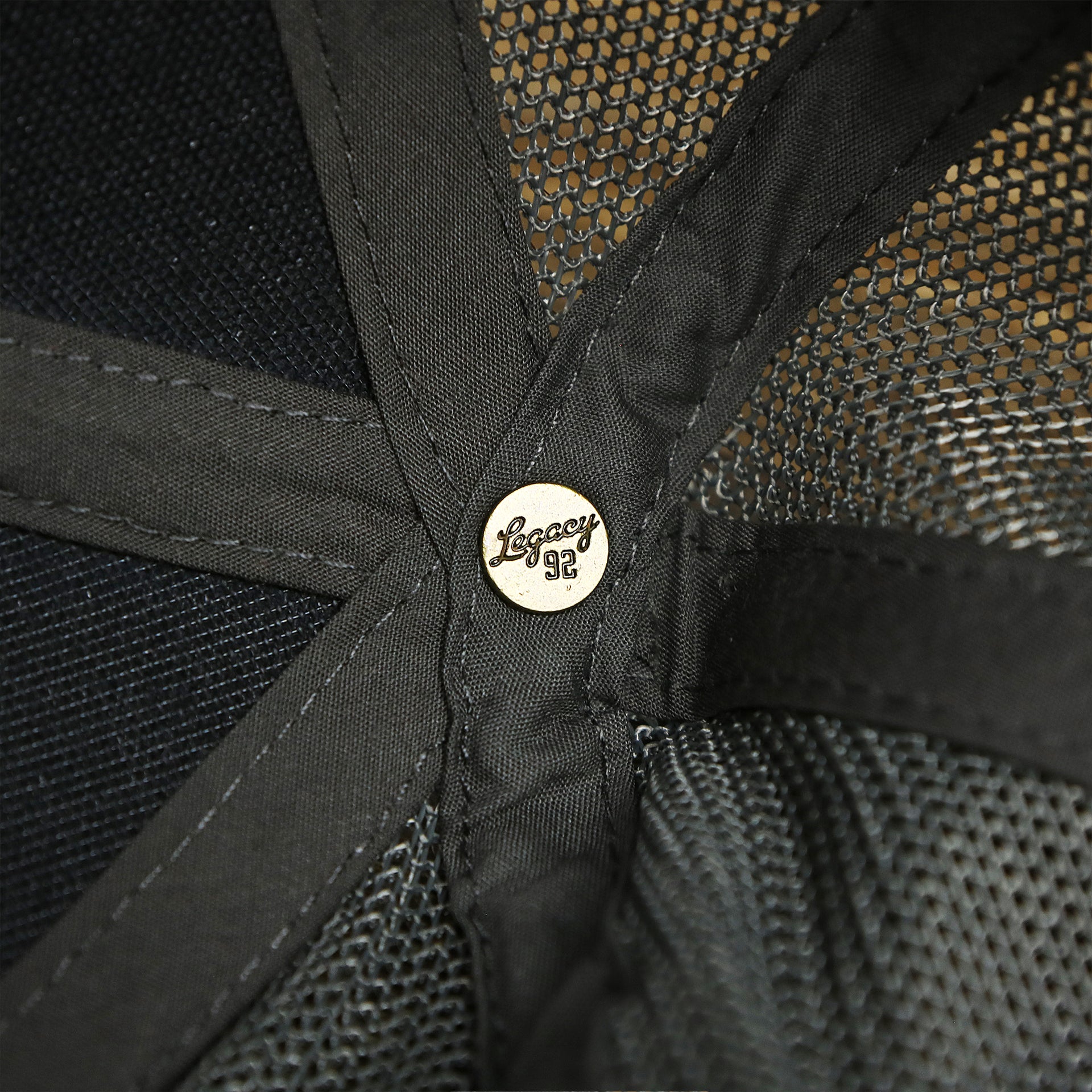 The Legacy Engraved Button on the OCNJ Ocean City 1879 Sunset Wave Logo Mesh Stretch FIt Hat | Dark Green And Dark Grey Stretch Fit Hat