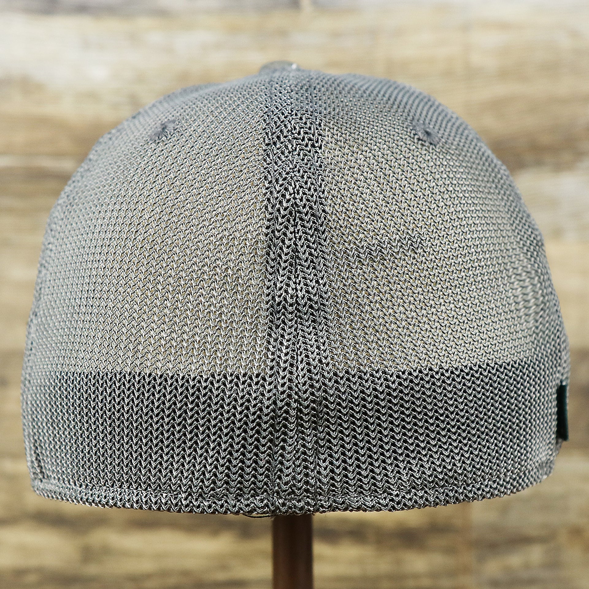 The backside of the OCNJ Ocean City 1879 Sunset Wave Logo Mesh Stretch FIt Hat | Dark Green And Dark Grey Stretch Fit Hat