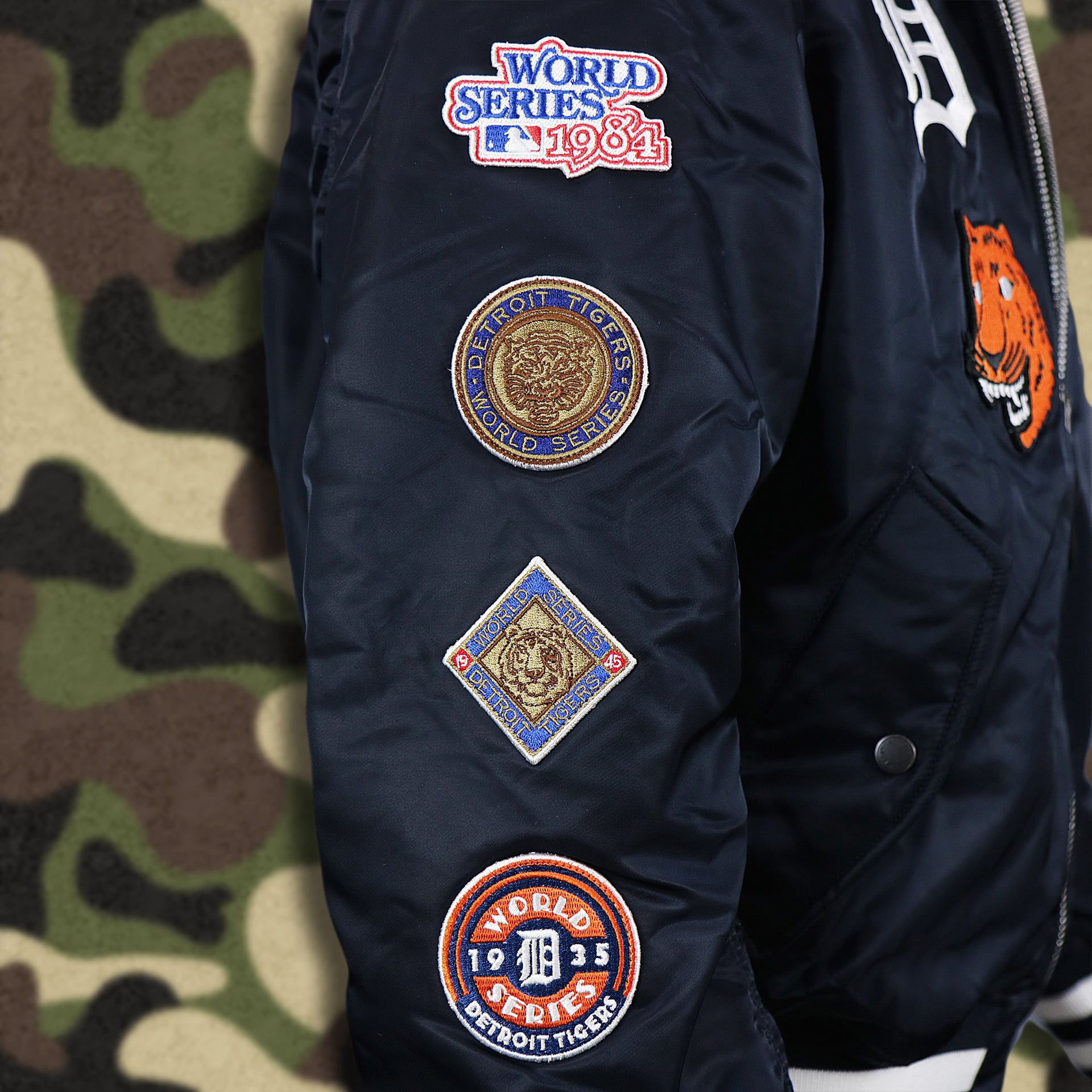 The Detroit Tigers World Series Side Patches on the Detroit Tigers MLB Patch Alpha Industries Reversible Bomber Jacket With Camo Liner | Navy Blue Bomber Jacket