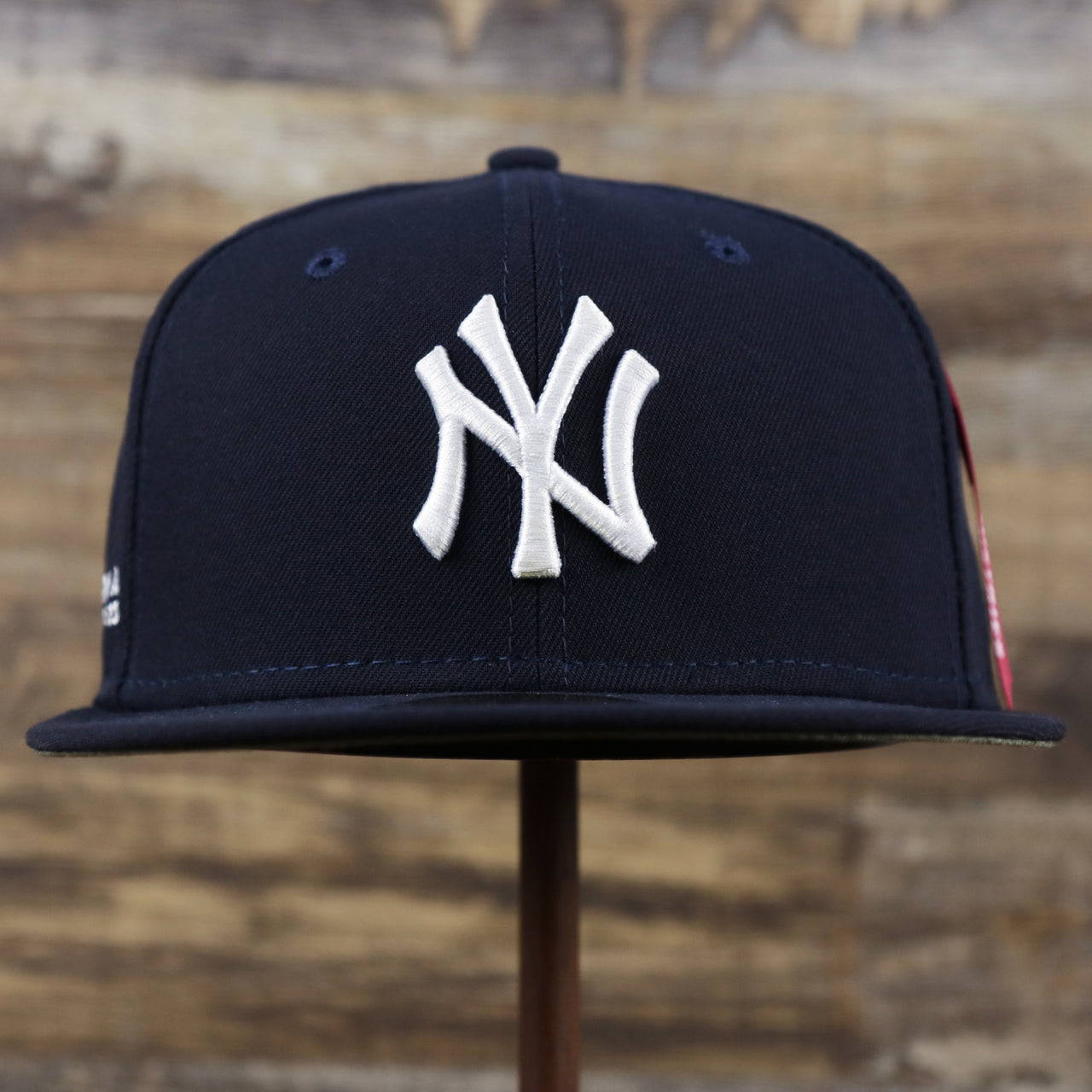 The front of the New York Yankees Alpha Industries Side Patch Army Green Undervisor 59FIfty Fitted Cap With Hangtag | Navy Blue 59FIfty Cap