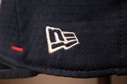 The new era logo is in white Patriots 2020 Training Camp Snapback Hat | New England Patriots 2020 On-Field Navy Training Camp Snap Cap