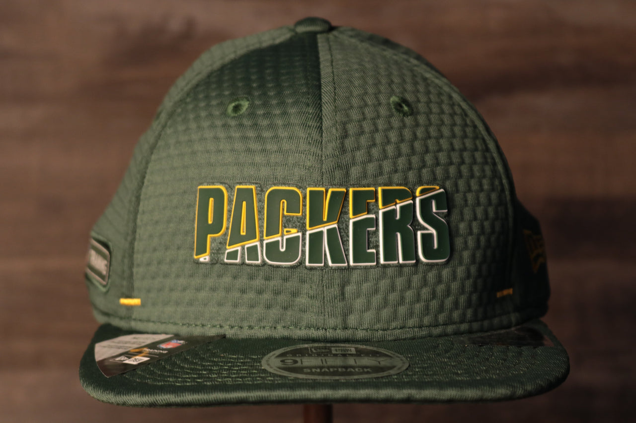 Packers 2020 Training Camp Snapback Hat | Green Bay Packers 2020 On-Field Green Training Camp Snap Cap the front of this packers hat has the packers name with a flat brim
