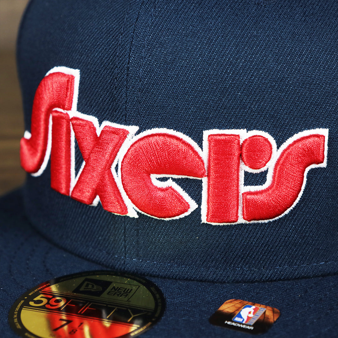 Close up of lettering on the Philadelphia 76ers 2021 Retro Spectrum City Edition Gray Bottom 59Fity Fitted Cap | Navy