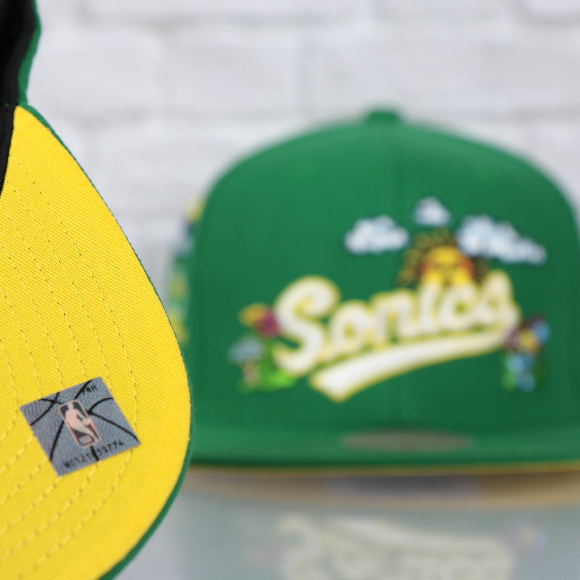 yellow under visor on the Seattle Supersonics Throwback Wordmark Hardwood Classics All Over Energy Psychedelic patch | Green Snapback hat