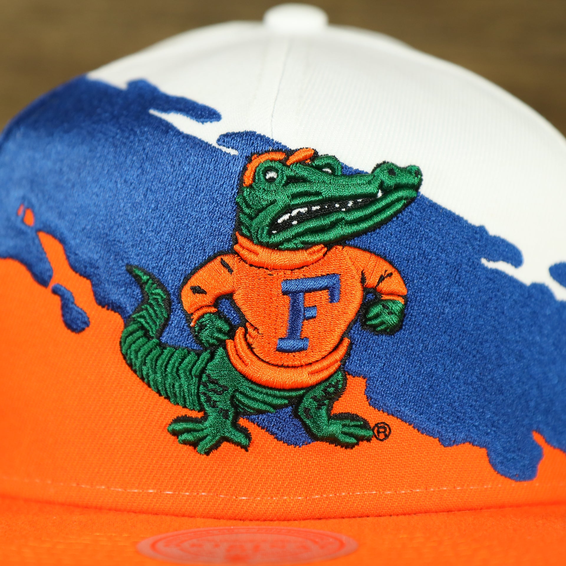 gators logo on the University of Florida Vintage Retro NCAA Paintbrush Mitchell and Ness Snapback Hat | Orange/Blue/White