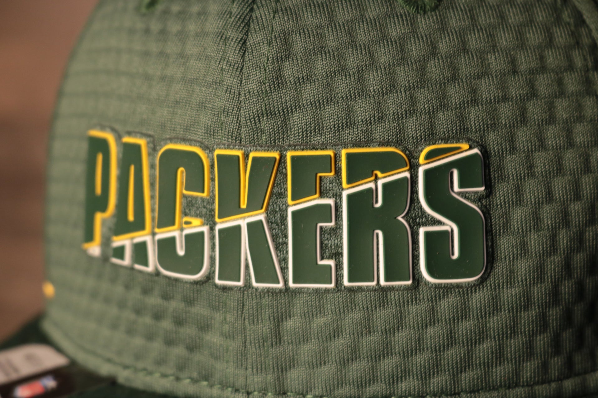 The packers logo is green with a yellow and white outline Packers 2020 Training Camp Snapback Hat | Green Bay Packers 2020 On-Field Green Training Camp Snap Cap