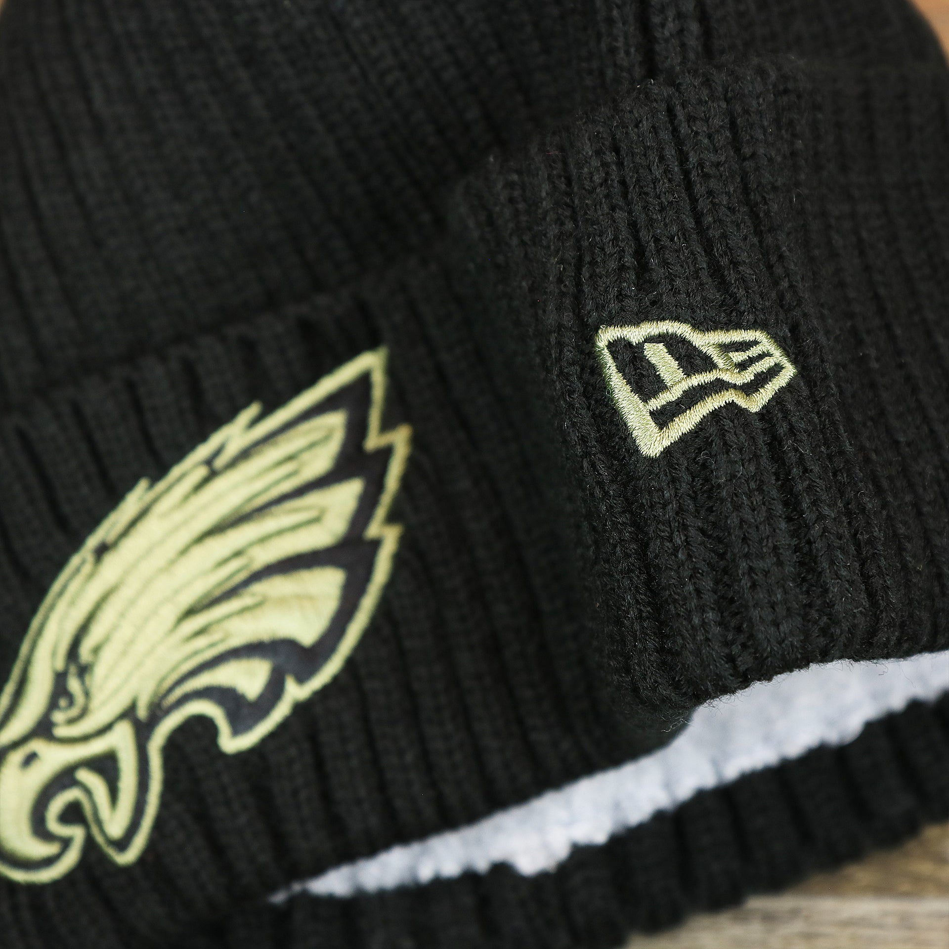 The New Era Logo on the Philadelphia Eagles Salute To Service On Field Cuffed Winter Beanie | Black Winter Beanie