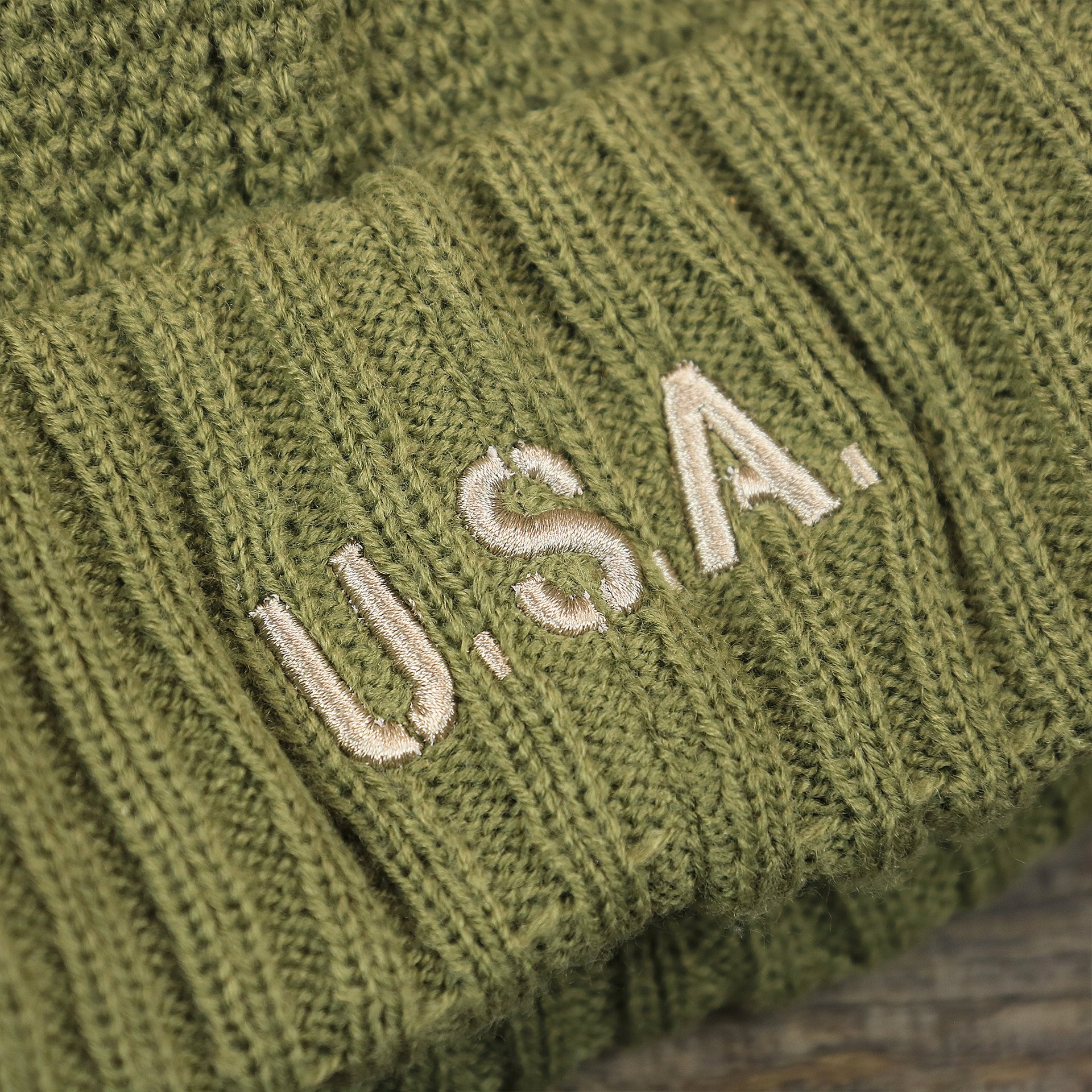 The USA Wordmark on the Women’s Dallas Cowboys Salute To Service Ribbon Rubber Military Cowboys Patch On Field NFL Beanie | Women’s Military Green Beanie