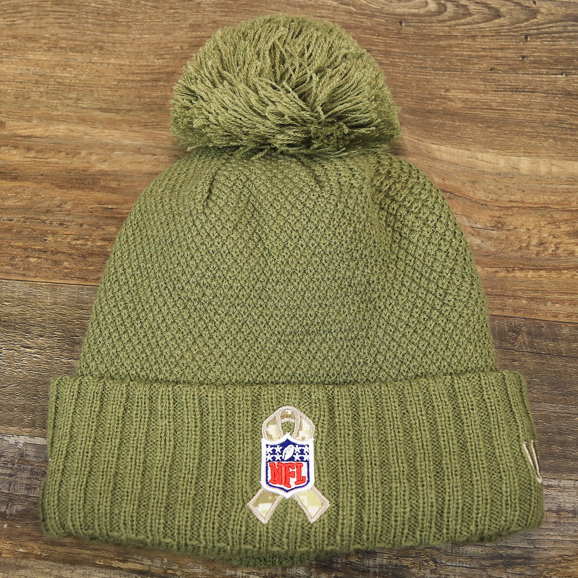 The backside of the Women’s Dallas Cowboys Salute To Service Ribbon Rubber Military Cowboys Patch On Field NFL Beanie | Women’s Military Green Beanie