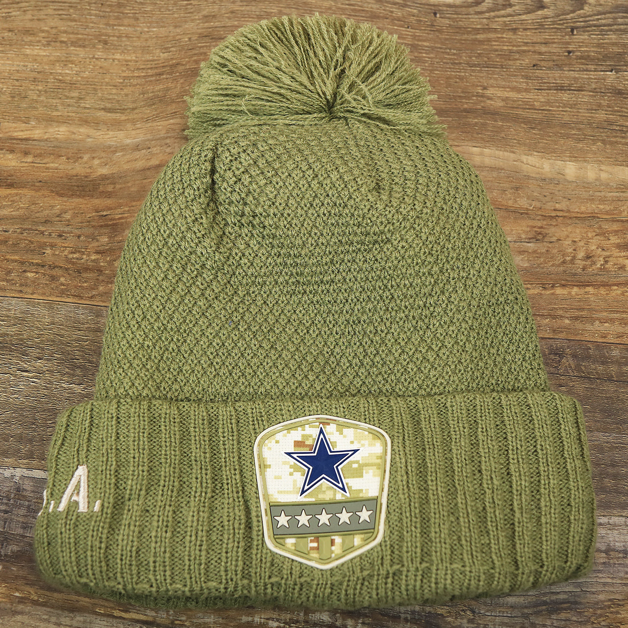The front of the Women’s Dallas Cowboys Salute To Service Ribbon Rubber Military Cowboys Patch On Field NFL Beanie | Women’s Military Green Beanie