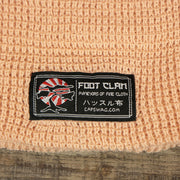 The Foot Clan Tag on the Dusty Pink Fisherman Knit Cuffed Beanie