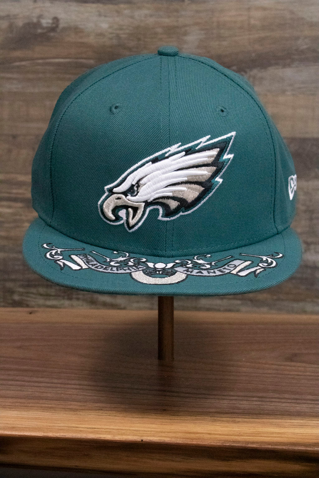 the Philadelphia Eagles NFL Draft 2019 Snapback Hat | Philly Eagles Midnight Green 9Fifty Snapback Draft Hat has an XL Eagles logo on the front and a Philadelphia Maneto slogan in latin on the brim