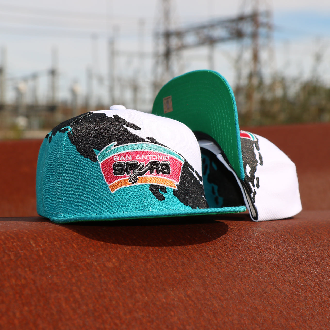 front and bottom of the San Antonio Spurs Vintage Retro NBA Paintbrush Mitchell and Ness Snapback Hat | Teal/White/Black