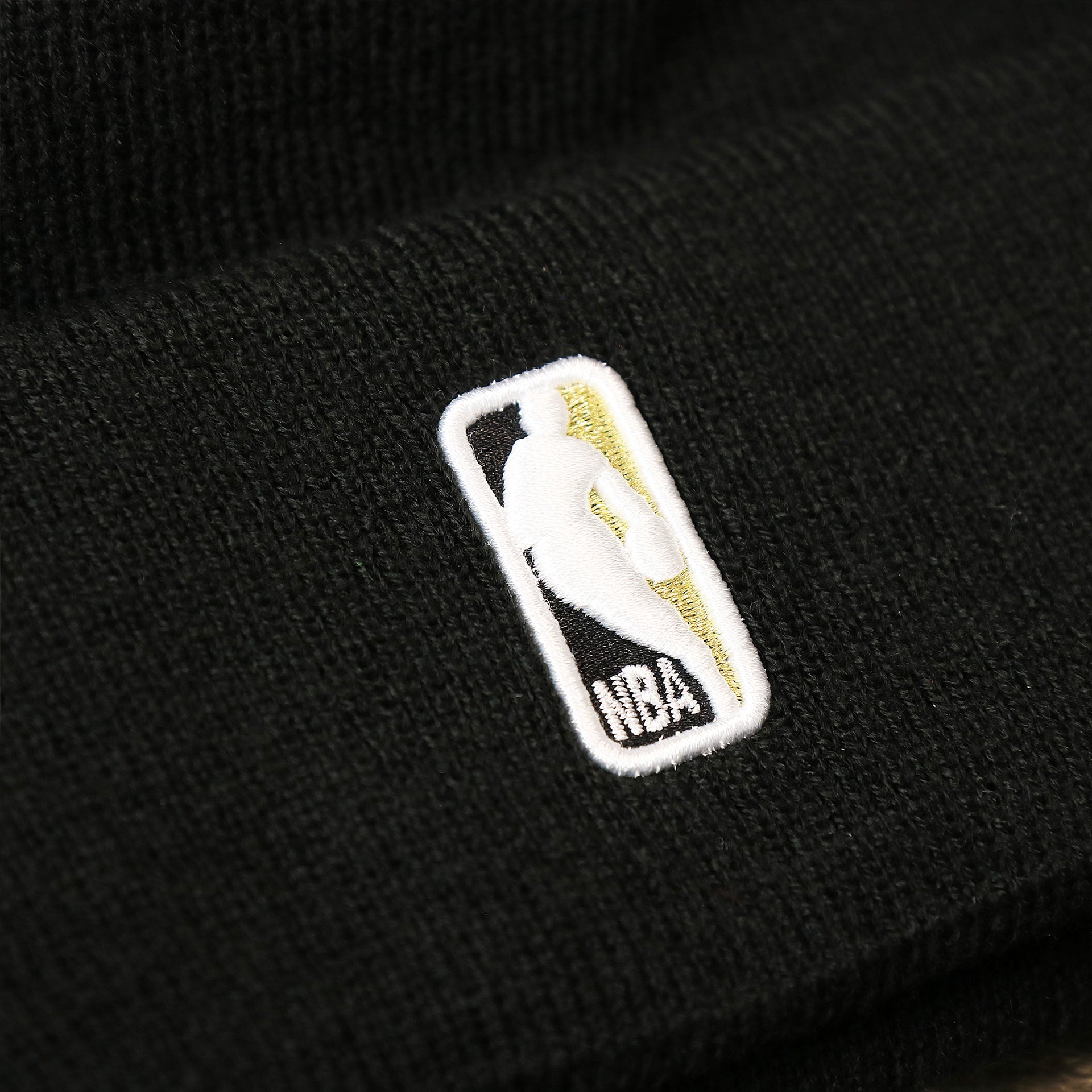 The NBA Jerrywest Logo on the Toronto Raptors NBA City Series Metallic Gold Leaf Winter Beanie | Black Winter Beanie