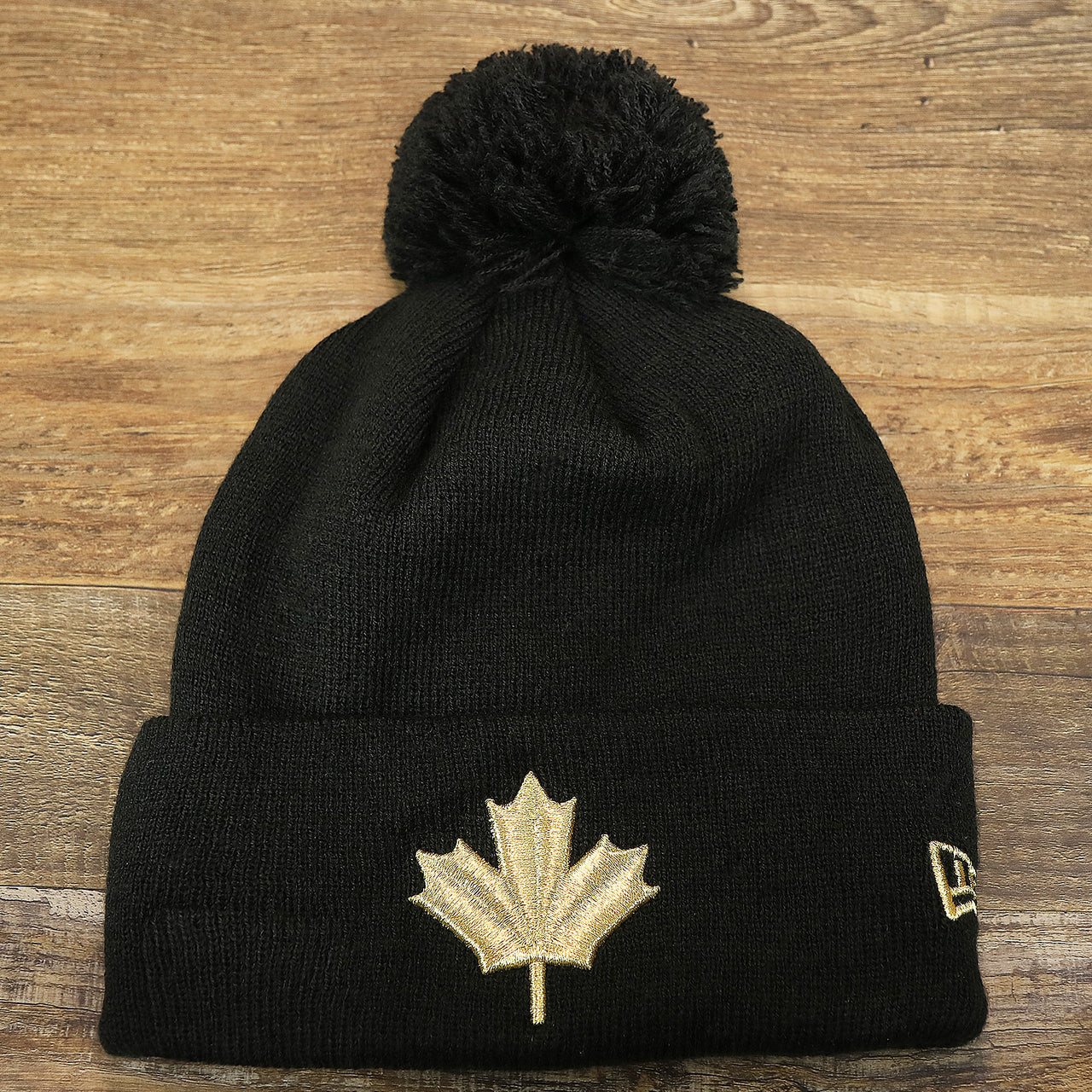 The front of the Toronto Raptors NBA City Series Metallic Gold Leaf Winter Beanie | Black Winter Beanie