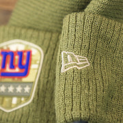 The New Era Logo on the New York Giants Salute To Service Ribbon Rubber Military Giants Patch On Field NFL Beanie | Military Green Beanie