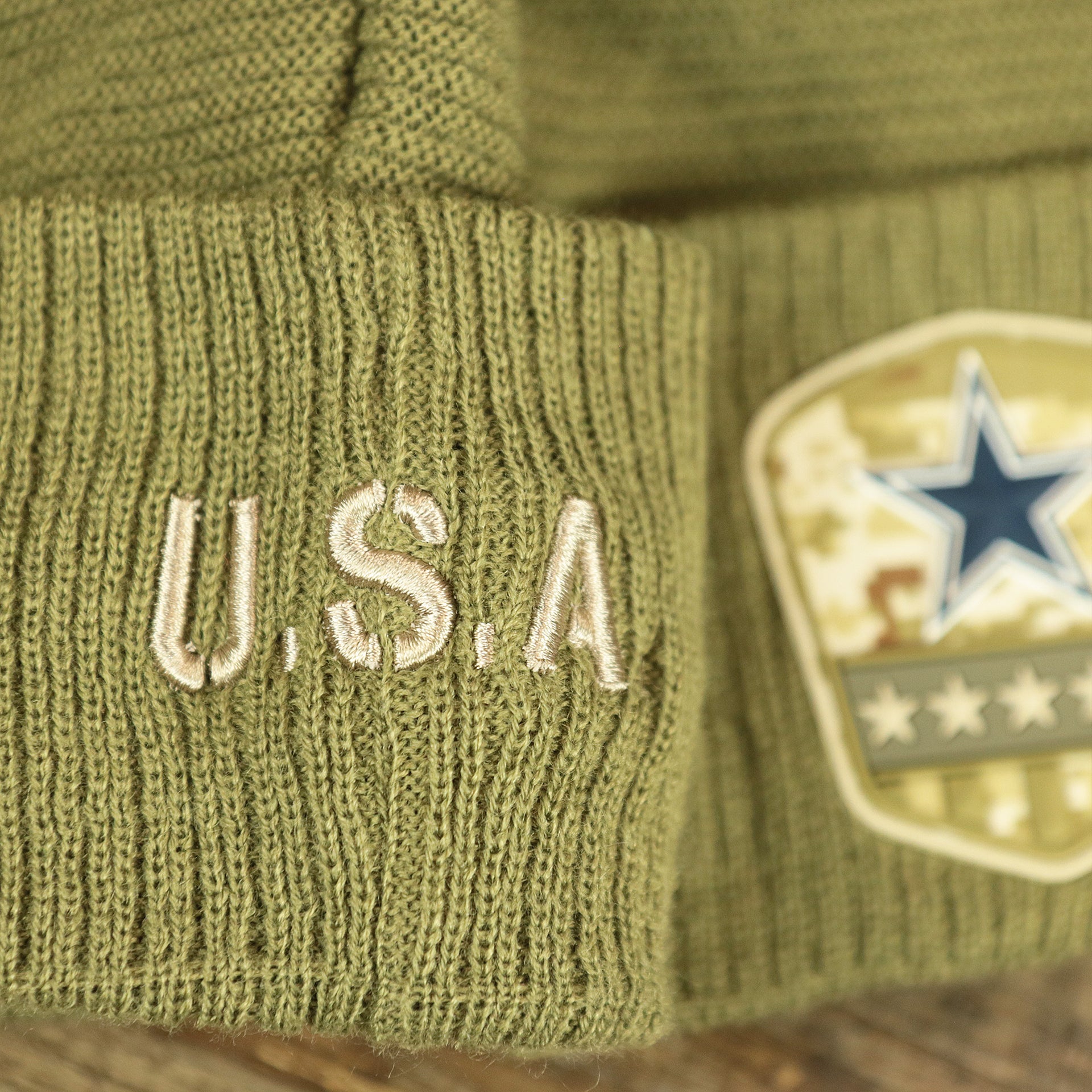 The USA Wordmark on the Dallas Cowboys Salute To Service Ribbon Rubber Military Cowboys Patch On Field NFL Beanie | Military Green Beanie